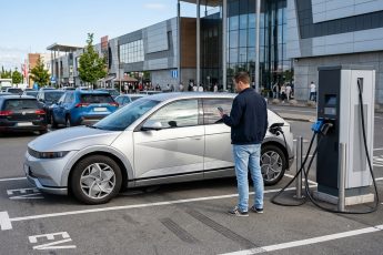 Быстрая зарядная станция постоянного тока на парковке торгового центра с подключённым электромобилем